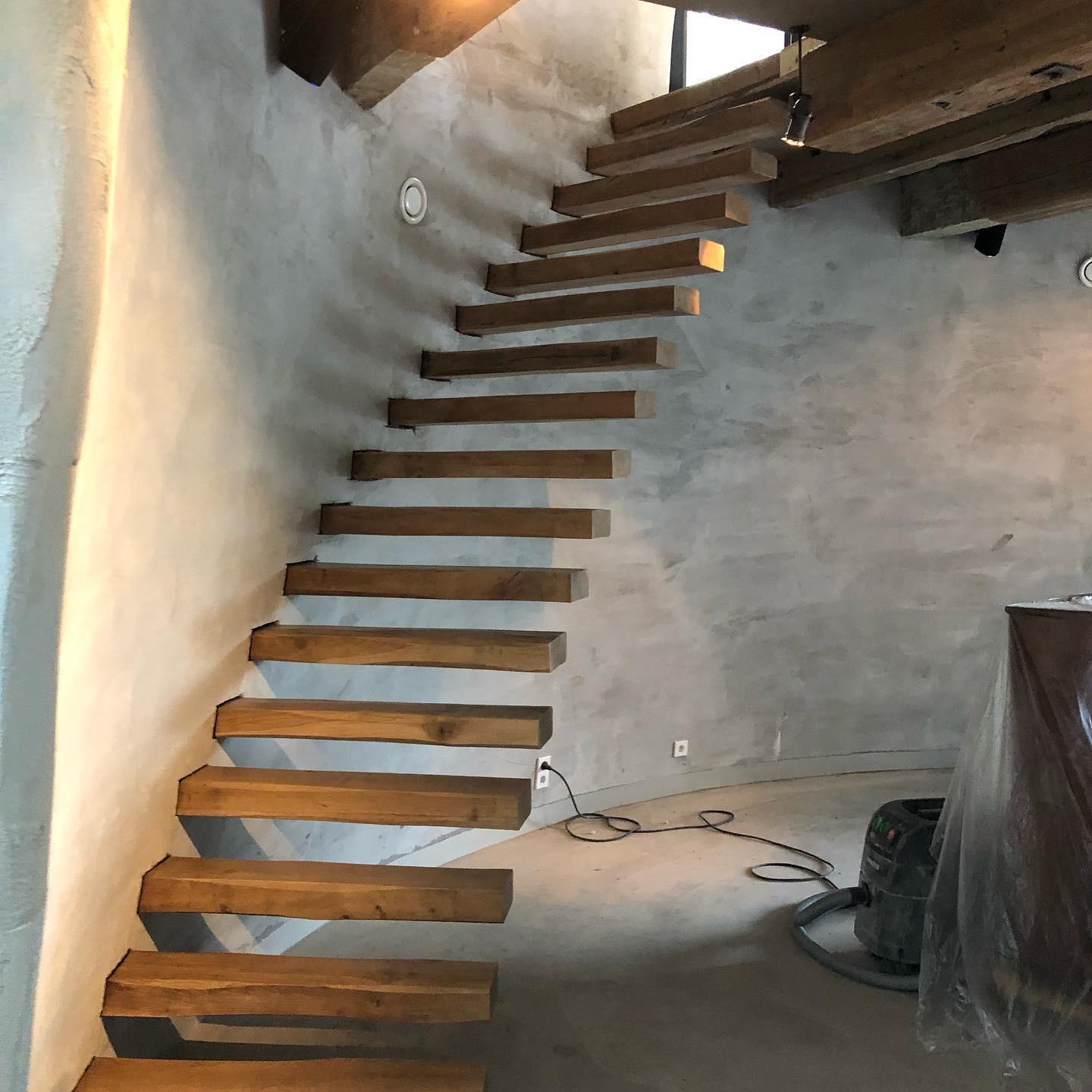 Moderne zwevende houten trap in gerenoveerde woonruimte